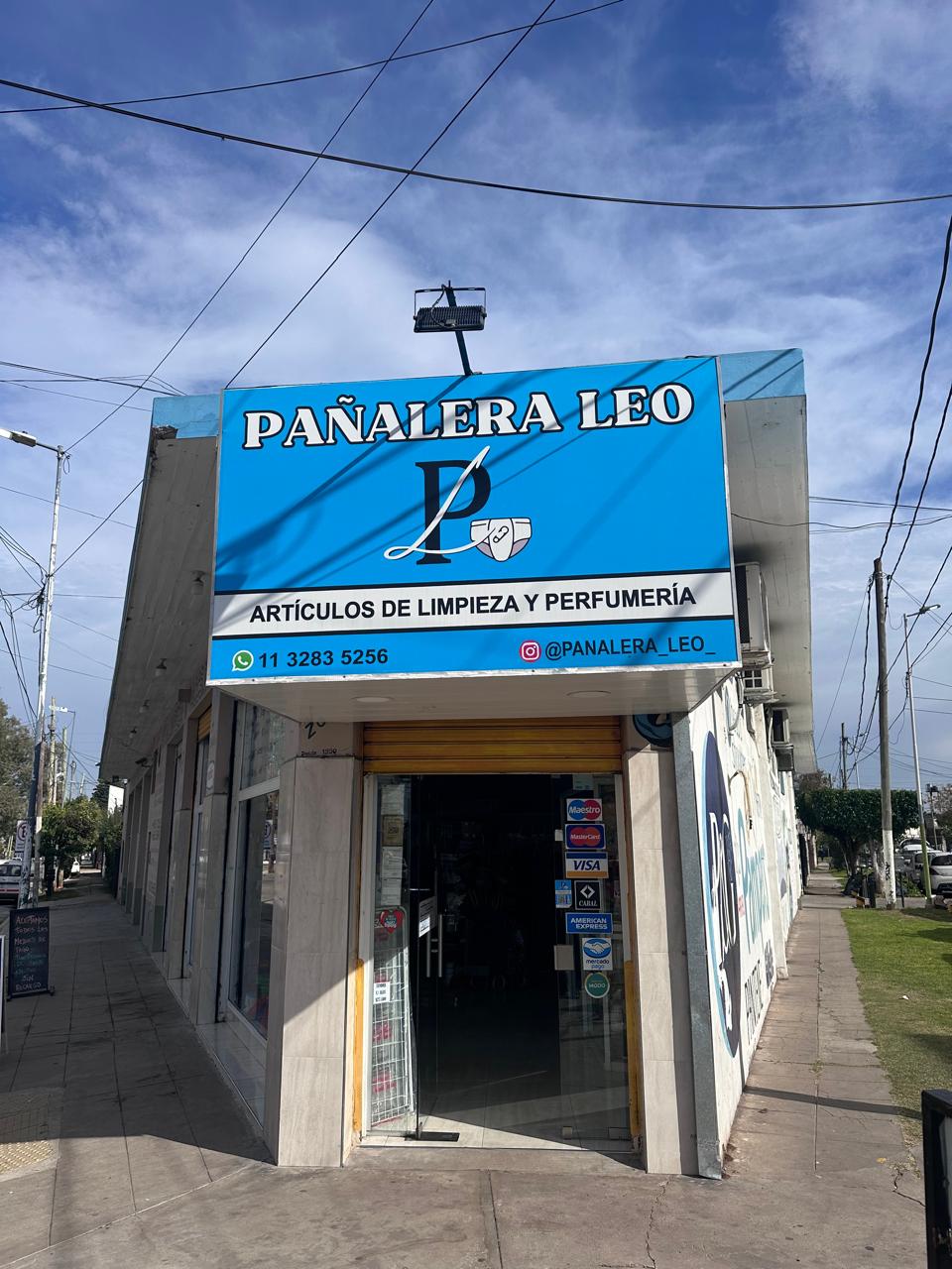 Frente de Pañalera Leo: cartel celeste con el logo, el WhatsApp y el Instagram, sobre la puerta de entrada.